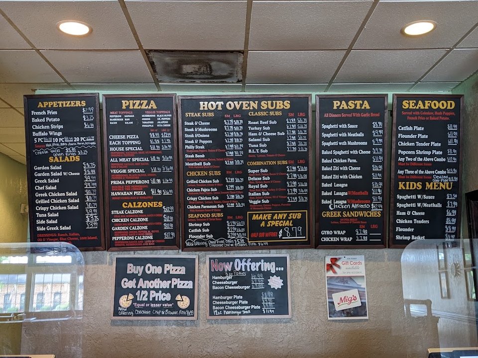 Restaurant menu showing chicken subs and burger plates.